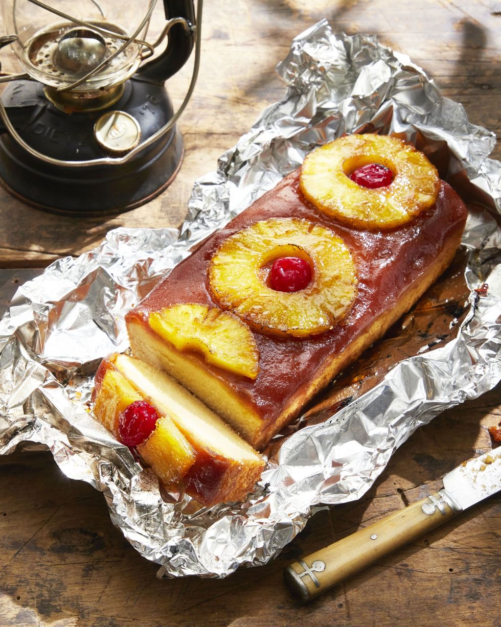 campfire grilled pineapple upside down cake on a sheet of foil on a wooden table