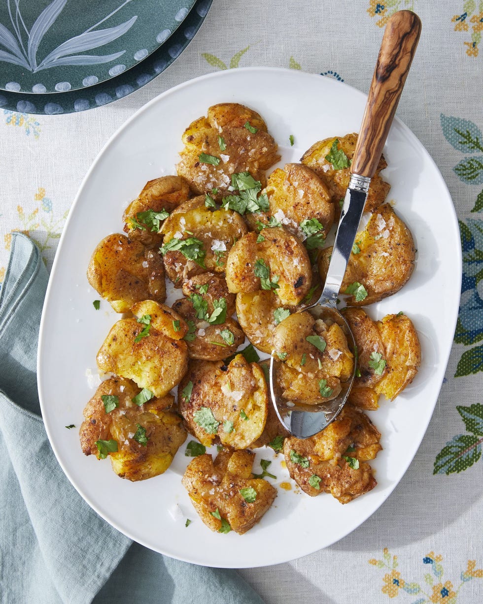 smashed potatoes with paprika and cumin on a white oval serving plate