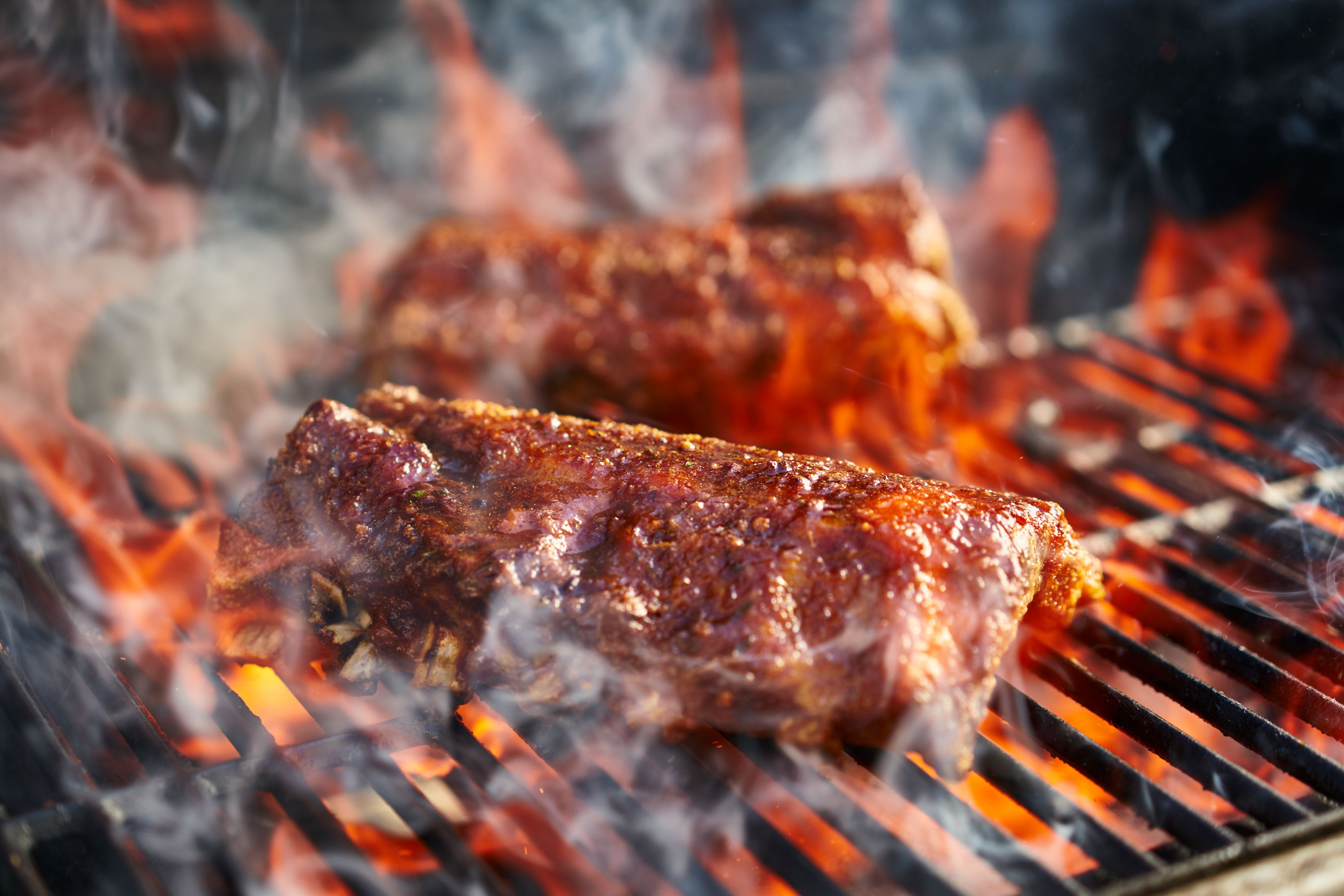 https://hips.hearstapps.com/hmg-prod/images/bbq-pork-ribs-cooking-on-flaming-grill-royalty-free-image-849128544-1541004995.jpg