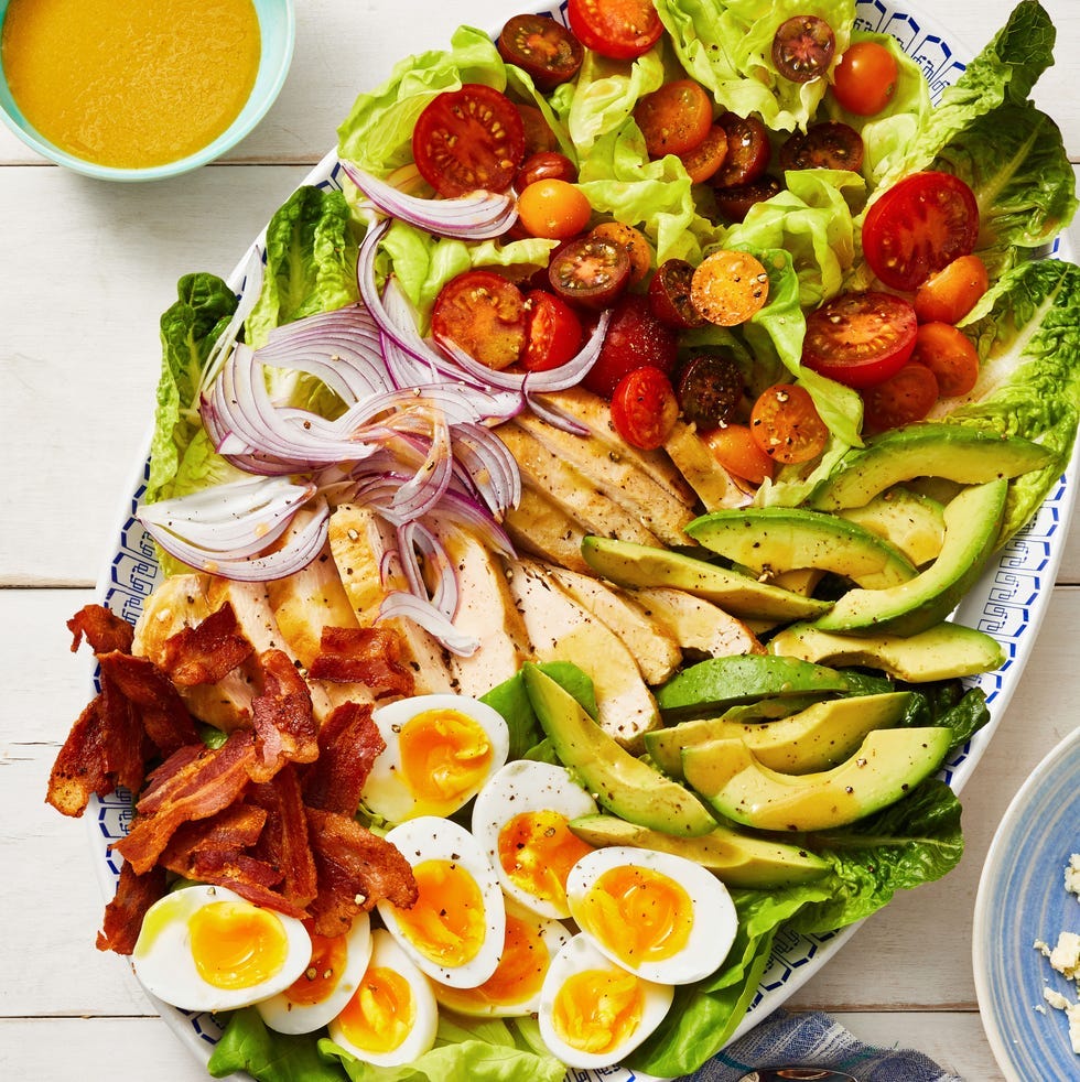 cobb salad with soft boiled eggs, bacon, avocado, tomatoes, and red onion