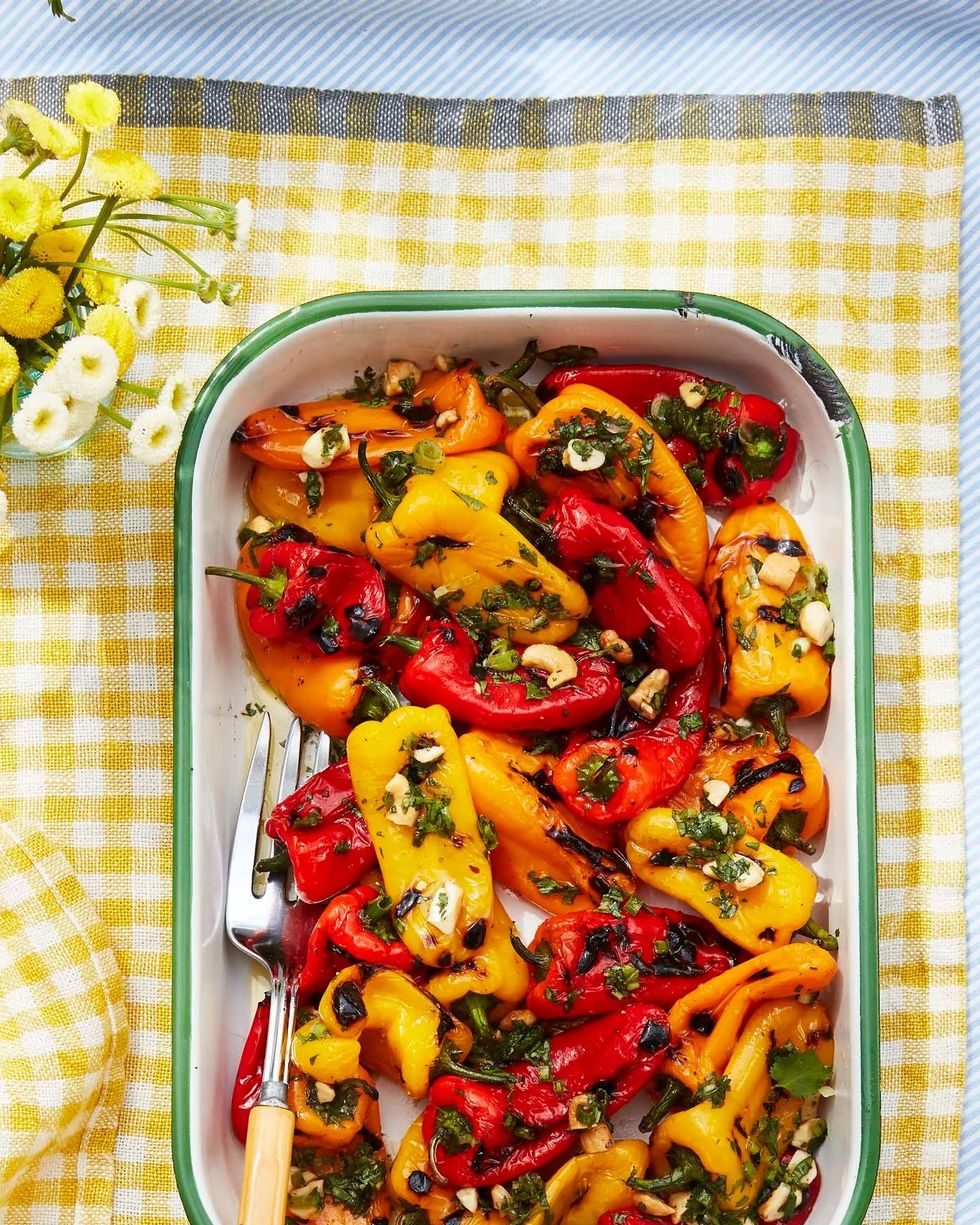 charred baby peppers with lime and cashew vinaigrette on a yellow tablecloth