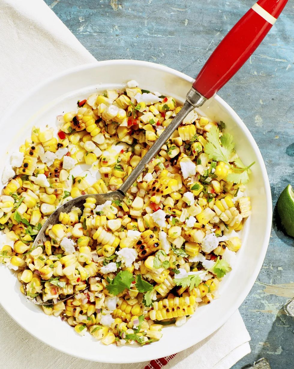charred corn salad in a serving bowl with a vintage serving spoon