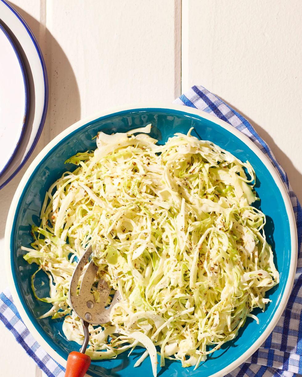 toasted seed coleslaw in a bowl with a spoon for serving