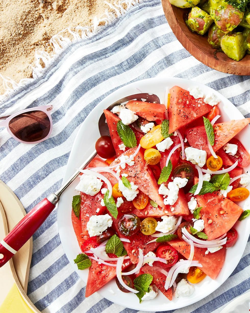 watermelon tomato and feta salad on a platter on a beach blanket