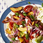 a summer salad with tomato, peaches, onion, and cheese