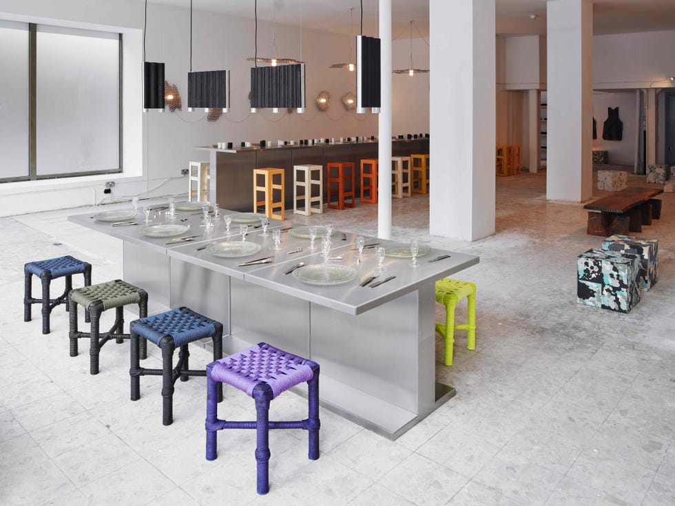 a spacious dining area featuring a long stainless steel table set for a meal