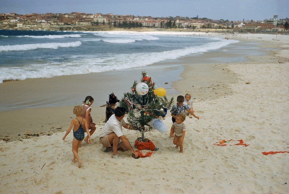 Een Australisch gezin versiert in 1956 een kerstboom op Bondi Beach in Sydney