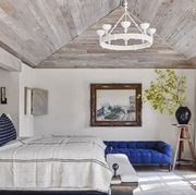 bedroomraising the ceiling, paneling it in pecky cypress, and reorienting the bed to face the glass doors made the room feel much bigger and brighter chandelier paul ferrante bench john derian for ciscohome linen spread, pillow, and vase prizehome  garden