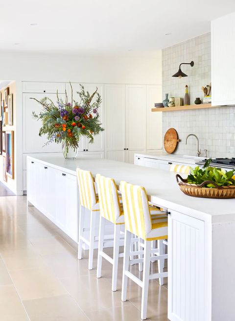 white kitchen with yellow bar stools