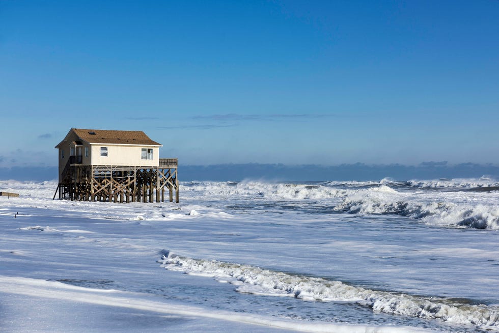 beach house on stilts surrounded by high tide surf