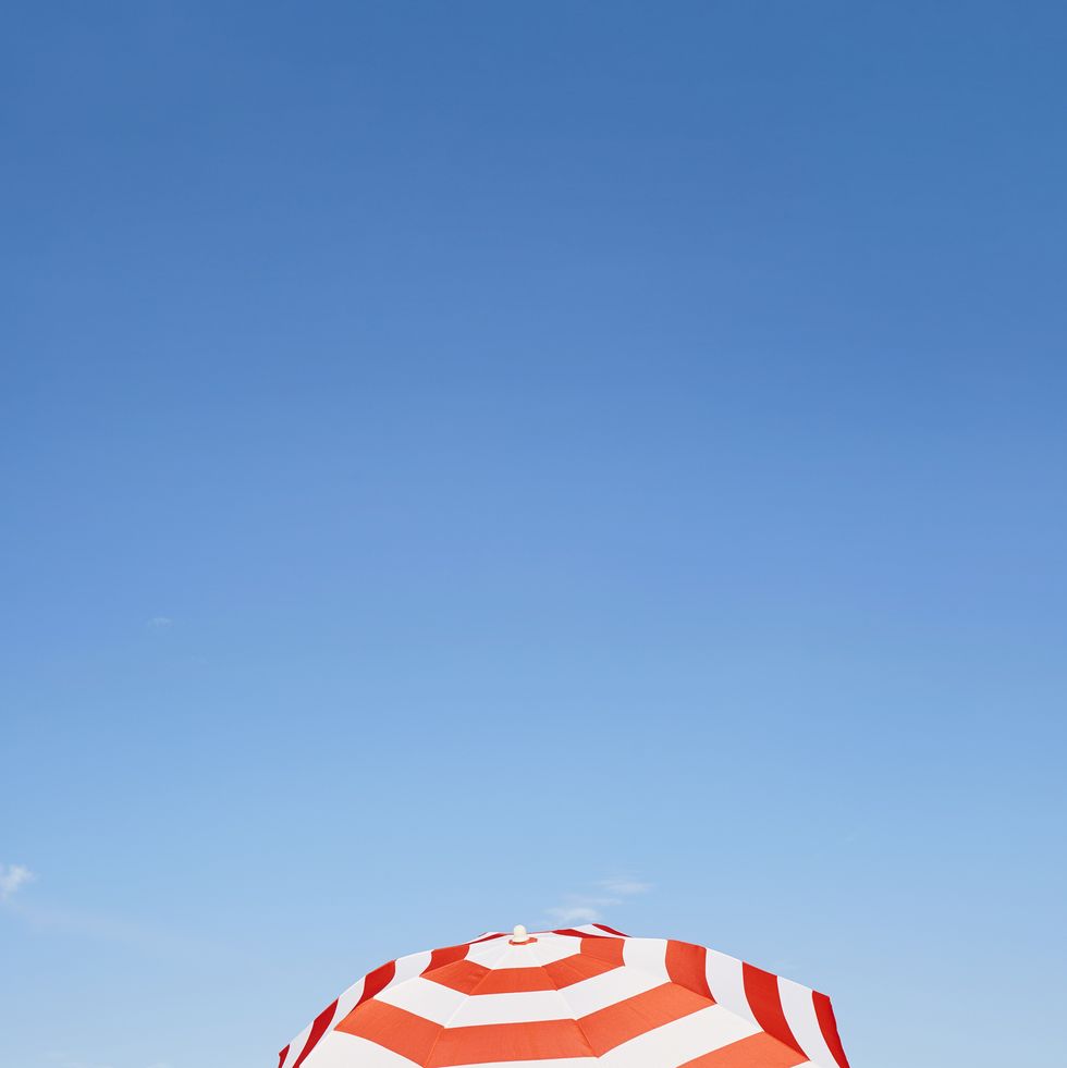 a red and white umbrella on a beach