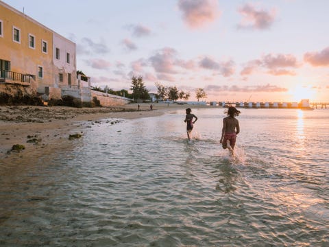 De zon gaat onder boven het strand bij het fort So Sebastio de oudste nog intacte vesting van  Afrika ten zuiden van de Sahara De bevolking maakt gebruik van de afnemende hitte om in de rosgouden zee te zwemmen