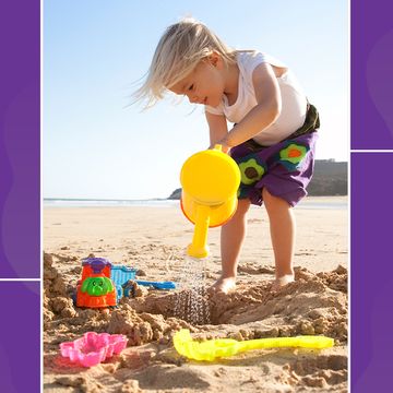 kid playing on beach with watering can and sand toys