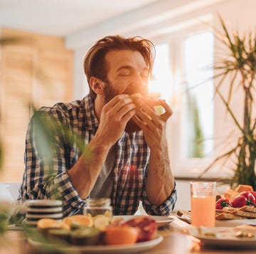 bearded man having a sandwich for breakfast at home