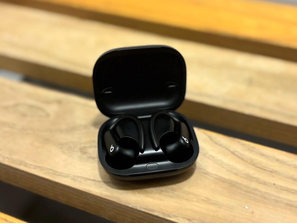 wireless earbuds in a charging case on a wooden surface