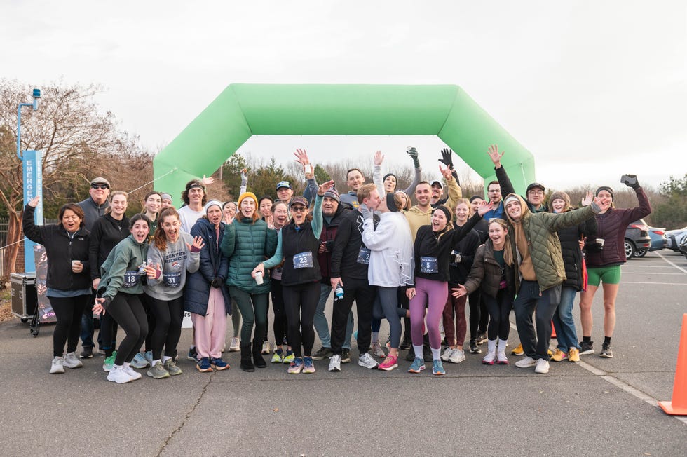 group of runners celebrating at a race event under an inflatable arch