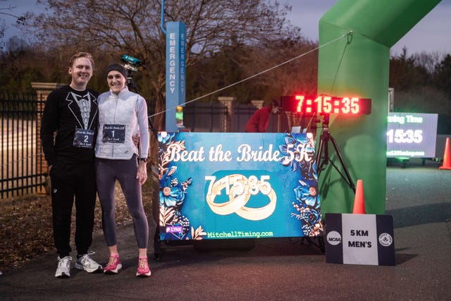 bride and groom pose in front of finish line