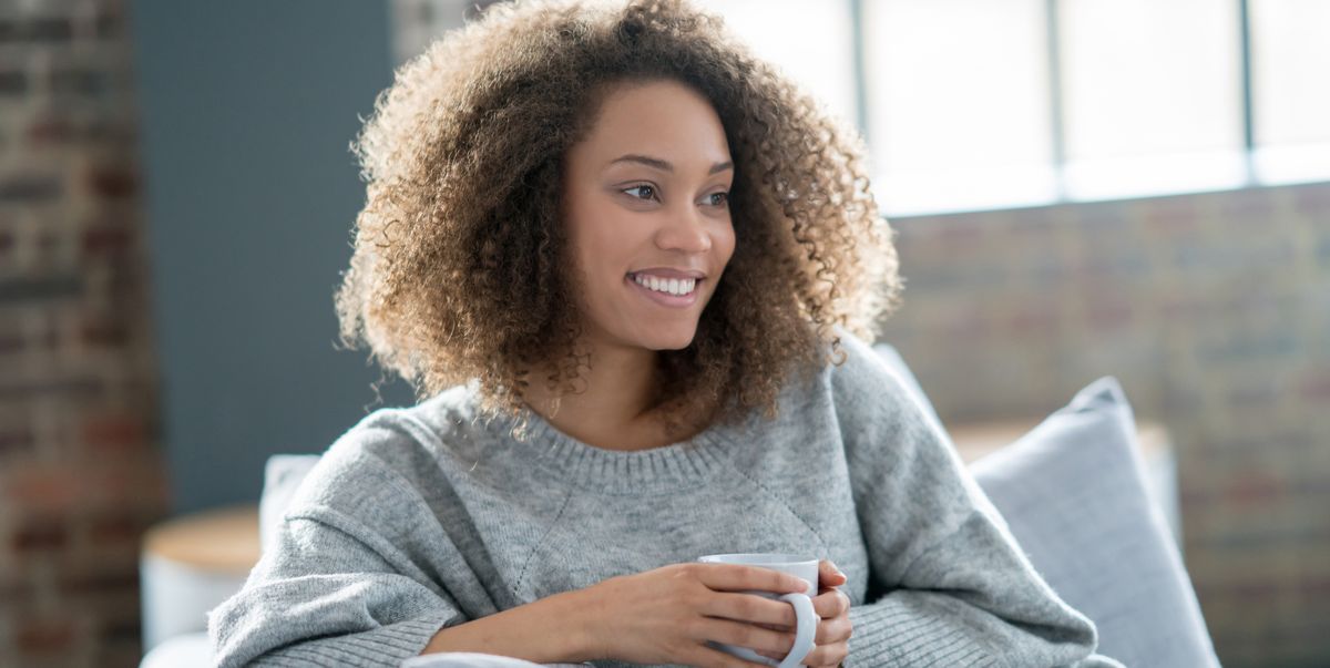 beautiful black woman drinking coffee at home