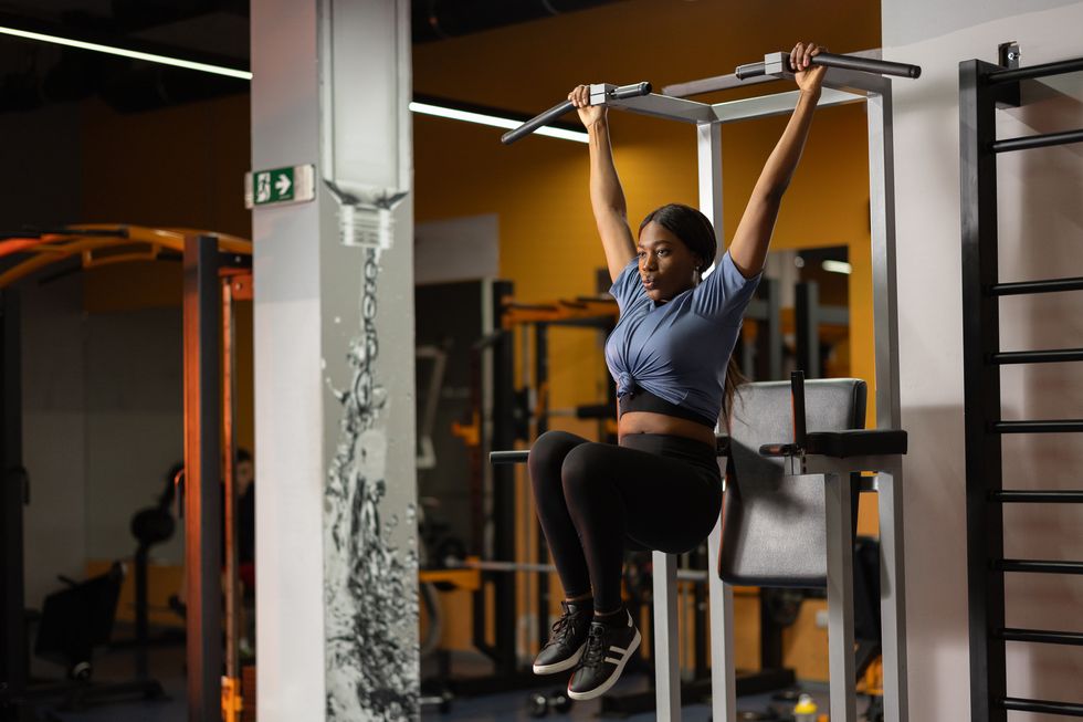 beautiful black woman working out on fitness exercise equipment at gym
