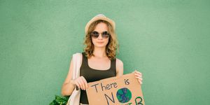 beautiful blonde girl holding there is no planet b over green background