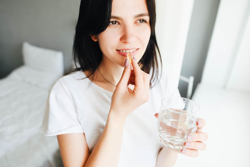 a beautiful dark haired girl drinks vitamins beautiful girl dark haired girl morning rituals water glass of water water balance in the body vitamins vitamins and dietary supplements