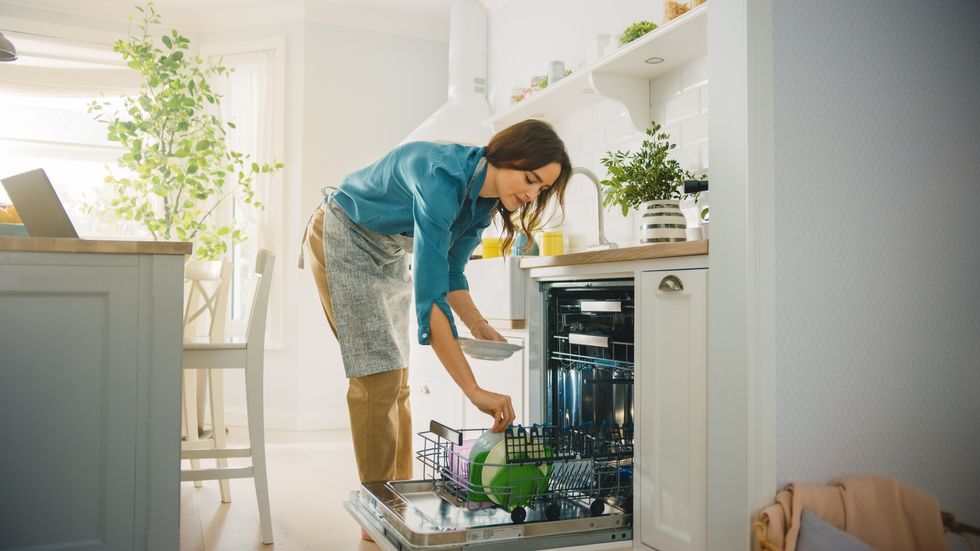 a woman loading a dishwasher