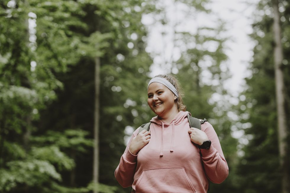 a beautiful female smiling while hiking in the forest