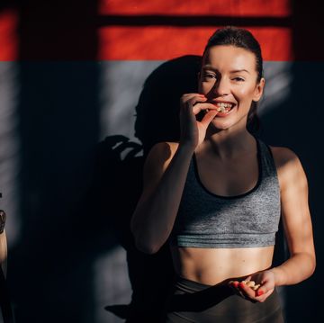 beautiful fit woman eating peanuts in gym