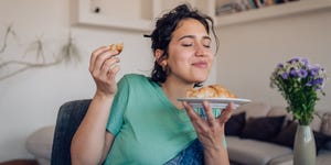 woman enjoying the taste of a fresh croissant