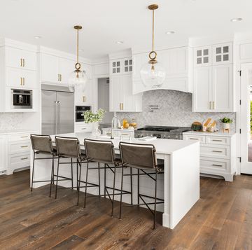 beautiful kitchen in new farmhouse style luxury home with island, pendant lights, and hardwood floors