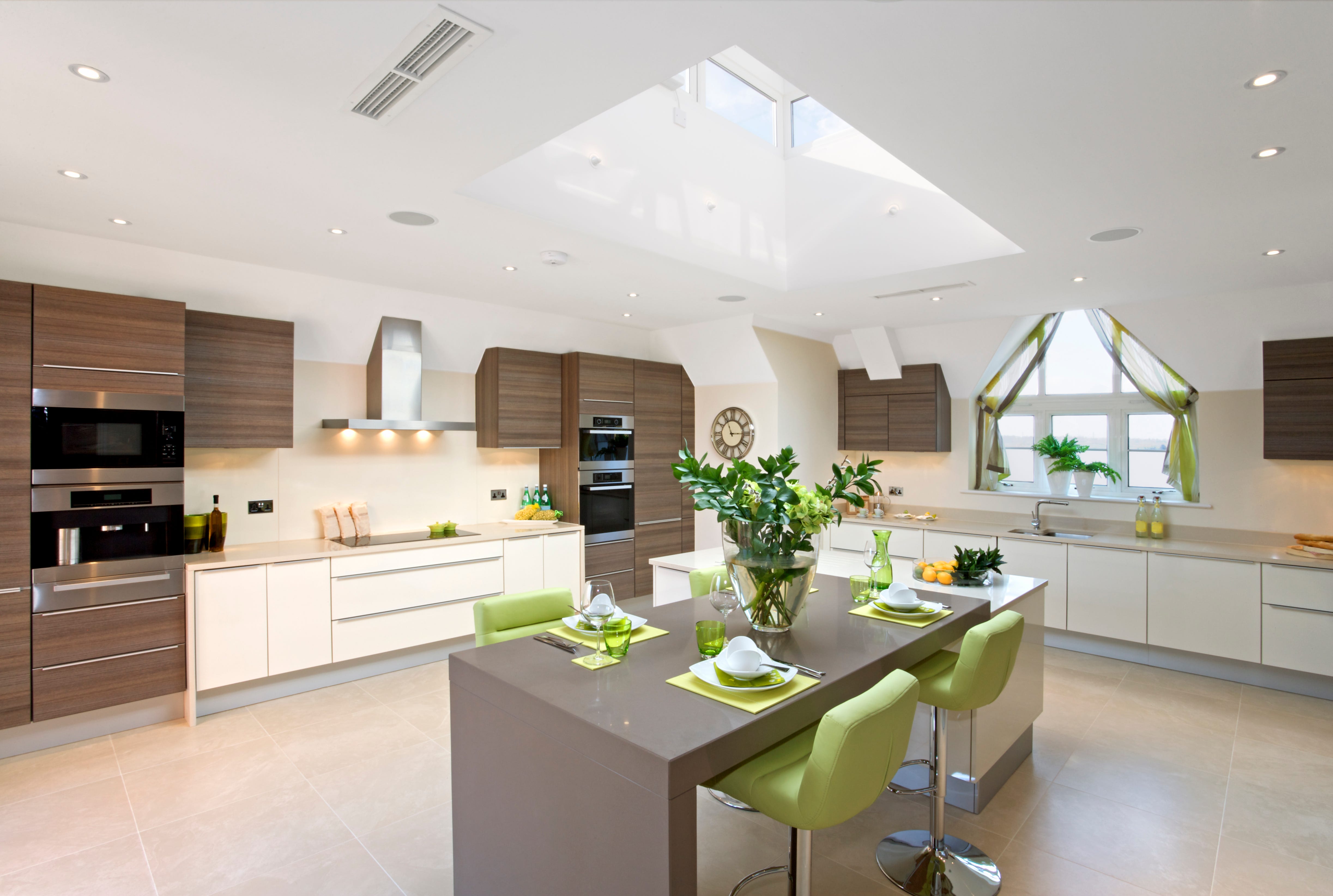 cocina grande con isla en verde, madera y blanco