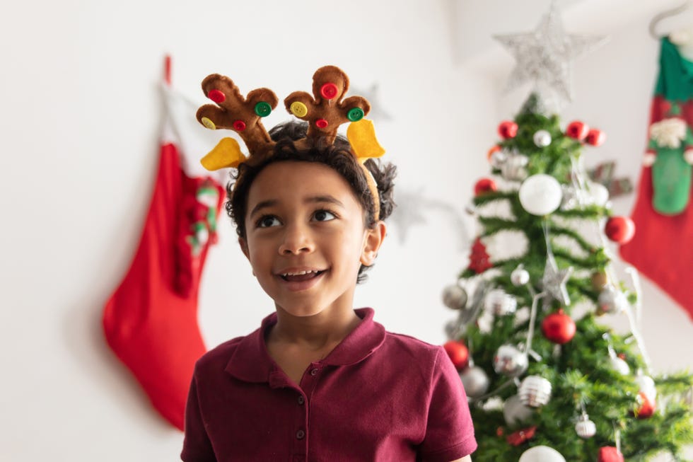 christmas trivia, beautiful little boy daydreaming while celebrating christmas looking up smiling