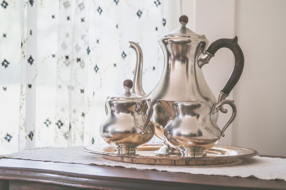 beautiful shot of silver metal teapots on a metal tray indoors