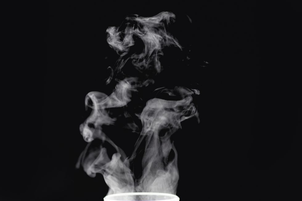 beautiful white abstract steam from tea or coffee on a black isolated background.