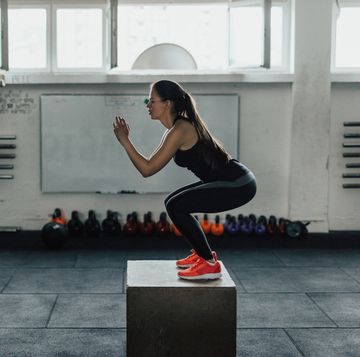 vrouw doet box squats in de sportschool