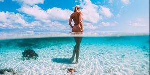 beautiful woman in tropical ocean, underwater fifty fifty photo bahamas island