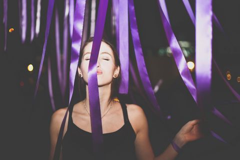 Beautiful Woman Kissing Purple Ribbon In Party