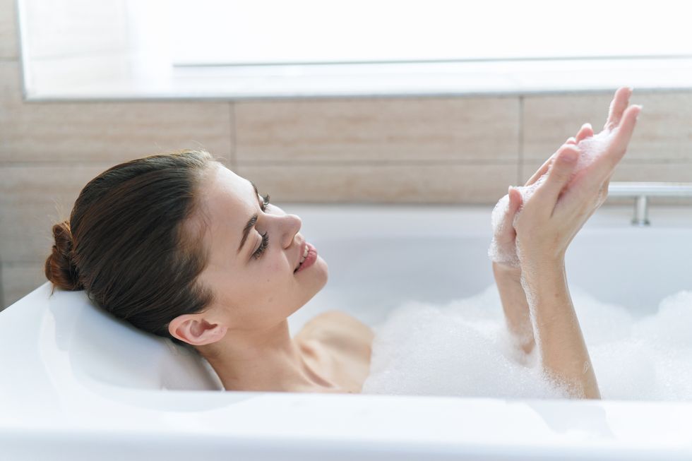 beautiful woman lies in a bubble bath and relaxes in a hot tub