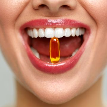 beautiful woman mouth with pill in teeth
