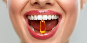 beautiful woman mouth with pill in teeth
