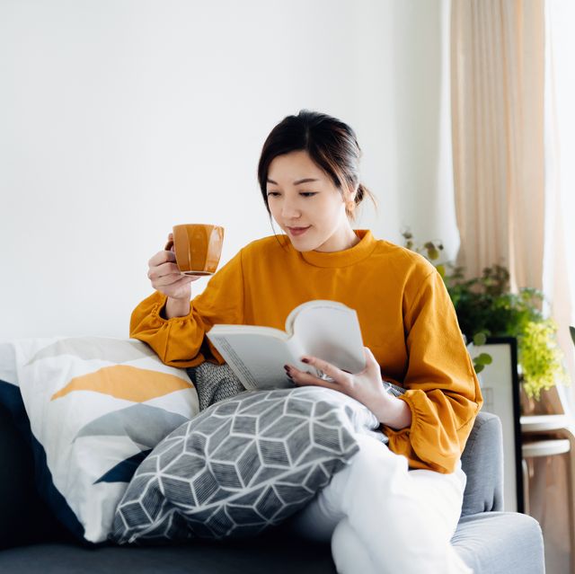 books about sex  beautiful young asian woman reading a book while drinking a cup of coffee enjoying a quiet time and relaxing environment at cozy home
