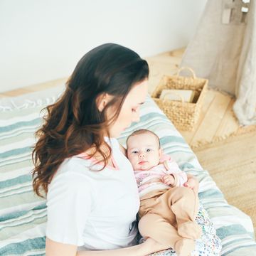 mujer sentada con bebe en cojin de lactancia