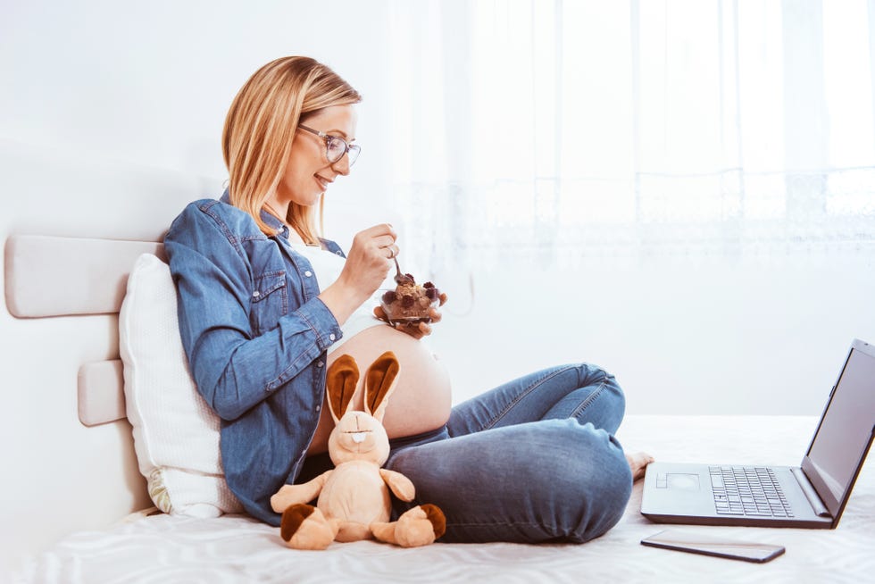 beautiful young pregnant woman eating ice cream