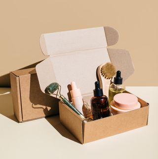 beauty box with face and body care products on beige background