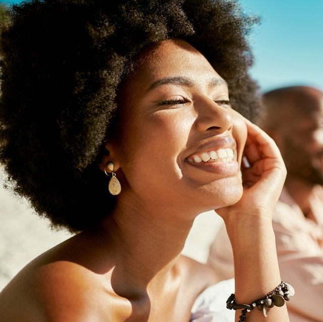 beauty, skincare and face of a beautiful woman glowing under the natural sunlight at the beach stunning afro girl smiling looking confident and happy with her soft, shining and flawless skin outdoor