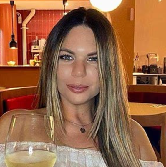 person holding a glass of drink in a dining setting