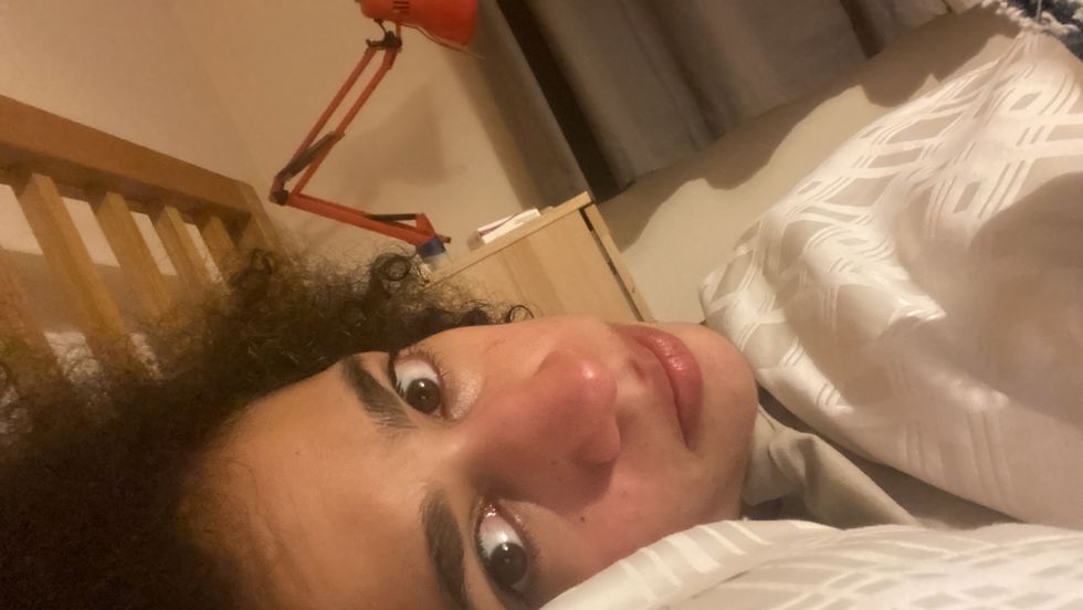 selfie penulis di tempat tidur dengan ekspresi netral diambil pada hari di mana kelelahan akibat covid yang panjang membuatnya tidak bisa bangun