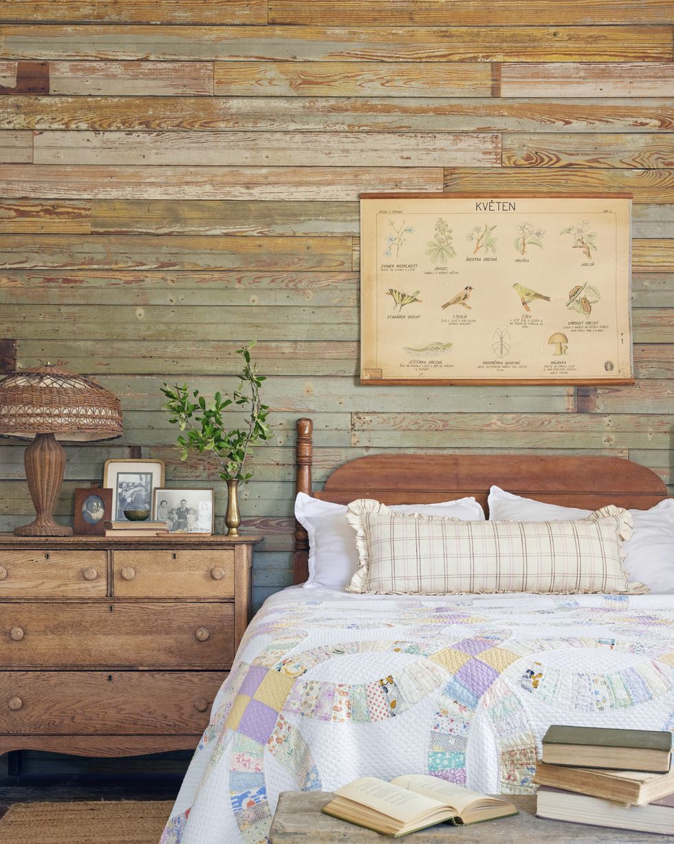 homeowners built the wall behind the headboard using wood salvaged from other parts of the house and there is a quilt on the bed