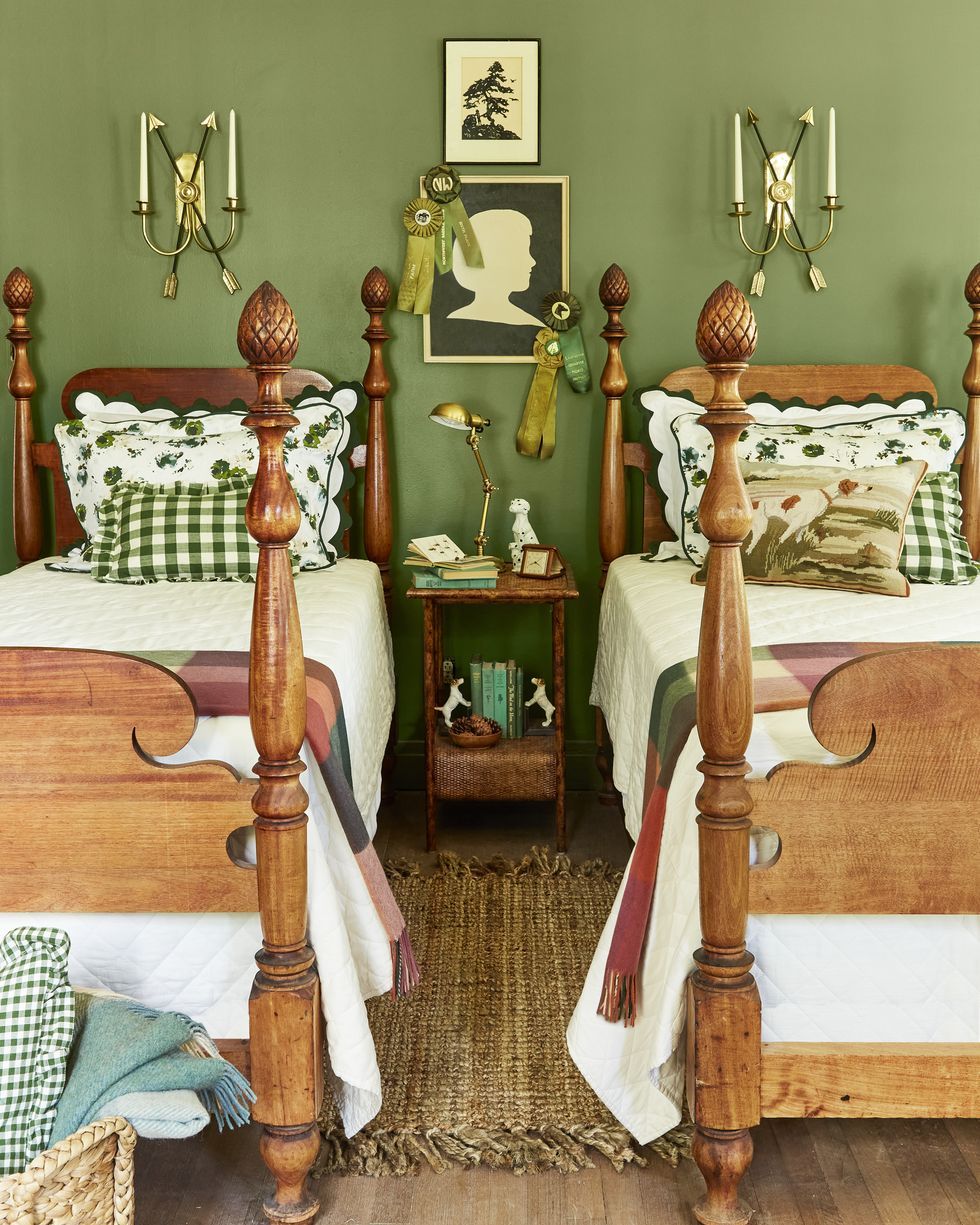a pair of wooden twin beds in a green bedroom