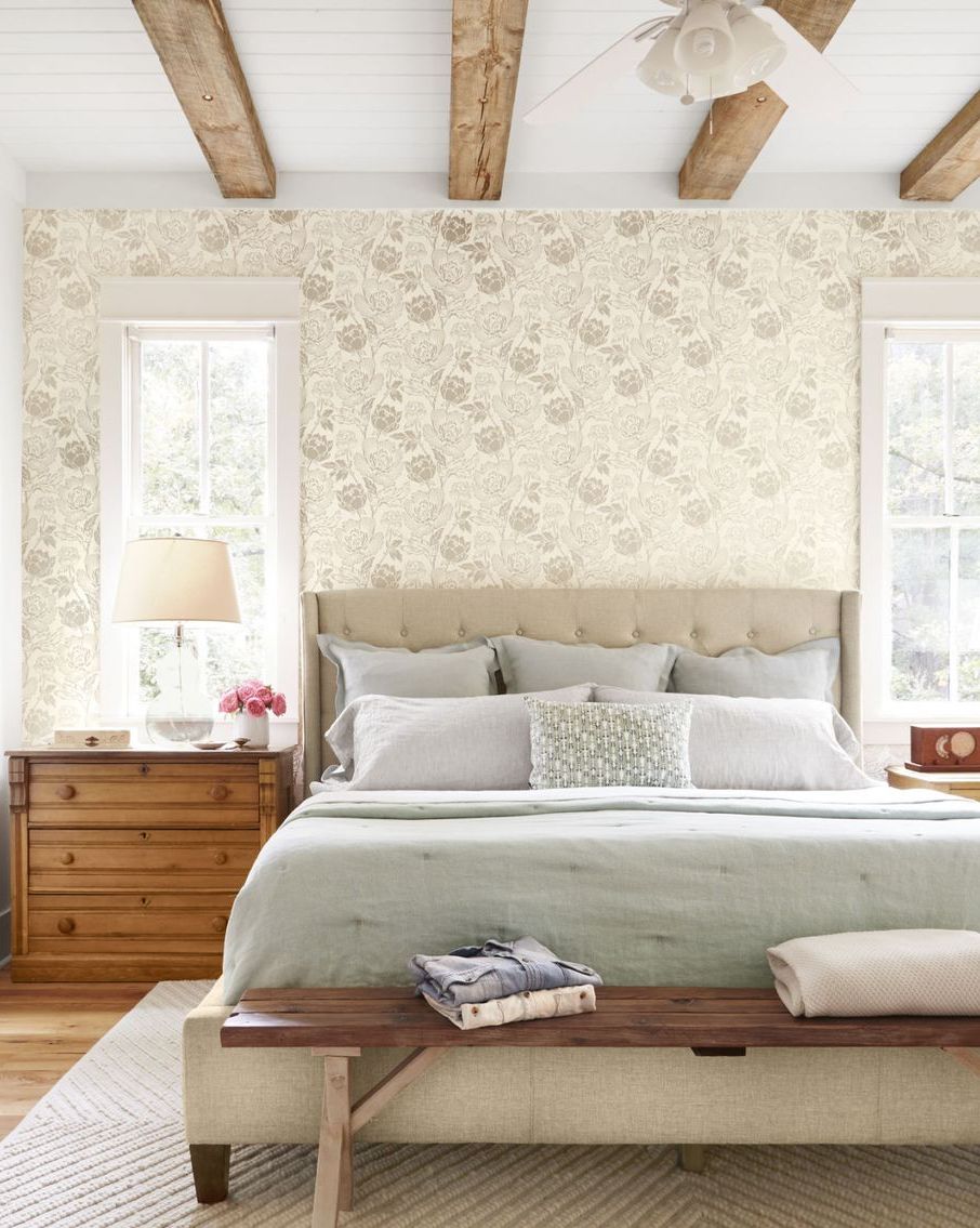 a sophisticated gray brown floral wallpaper mimics the hue of the weathered ceiling beams and offers a feminine but not frilly foil to the rooms rustic elements